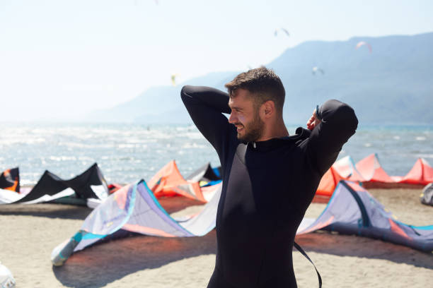 A man is preparing for kiteboard on the beach