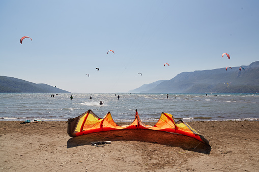 A young woman kitesurfer rides the waves doing a trick. Marine sports. kitesurfing.