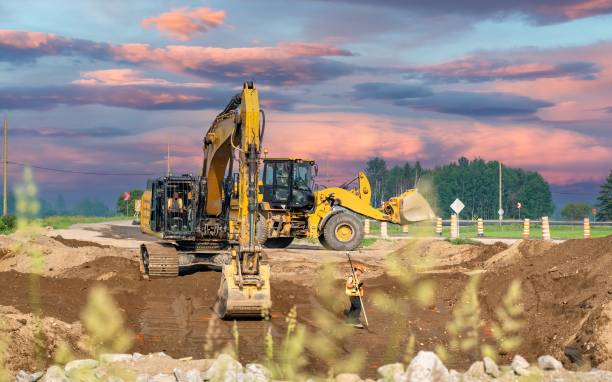 istock Excavator, loader and surveyor working on a road construction site 1501299155