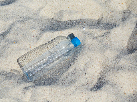 used plastic water bottles Abandoned on the white sand beach The global plastic pollution crisis degradation that is harmful to marine life