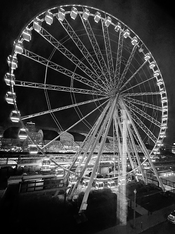 In black and white, an illuminated Ferris Wheel at night in St. Louis, MO.