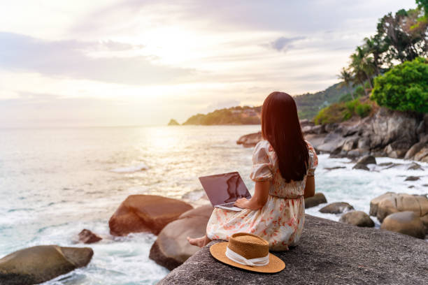 Young woman freelancer traveler working online using laptop while traveling on summer vacation, Freelance and workation concept stock photo