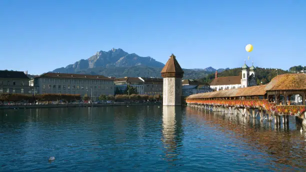 Famous chapel-bridge in Lucerne in Switzerland. The bridge was build in the year 1365, it is the oldest and longest (204 m) bridge with a roof in Europe. Mt Pilatus is on the background.