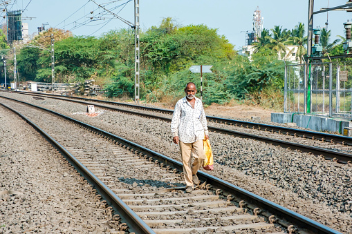 Pune, India - May 06 2023: Man walking on railway tracks at Hadapsar near Pune India.