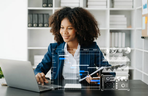 istock African woman hand Project manager working and update tasks and Gantt chart scheduling virtual diagram.with smart phone, tablet and laptop in office. 1501429960