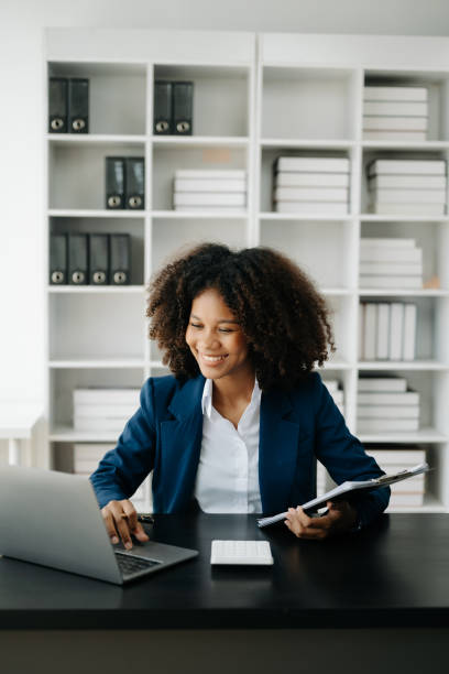 afrykańska kobieta freelancer pracuje na komputerze, tablecie i laptopie robi raport z analizy księgowej, dane inwestycyjne dotyczące nieruchomości, finanse w biurze - computer people data job zdjęcia i obrazy z banku zdjęć