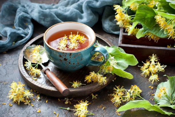 istock Cup of linden tea and  fresh  flowers on  dark  table 1501450678