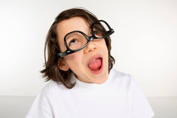 Portrait of a young boy. 10 year old boy make face on white background. White t-shirt and red sweatpants. white people.