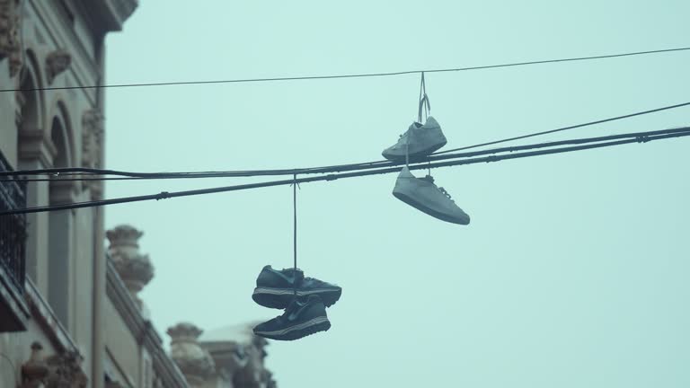Sneakers hanging on electric wires in rainy weather