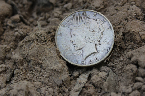 istock 1922 Silver Peace Dollar On Ground in Dirt. Front View 1501473624