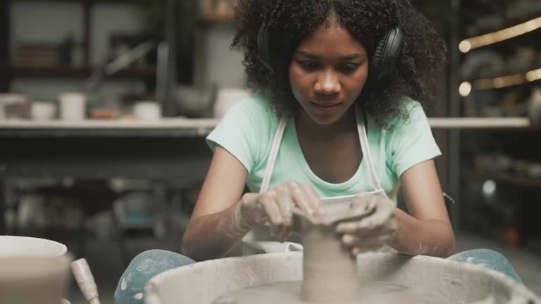 Teenager girls is making pottery as leisure activity.