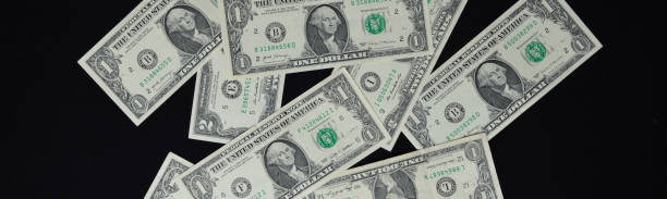 istock dollar bills scattered in a chaotic manner on a black background 1501527079
