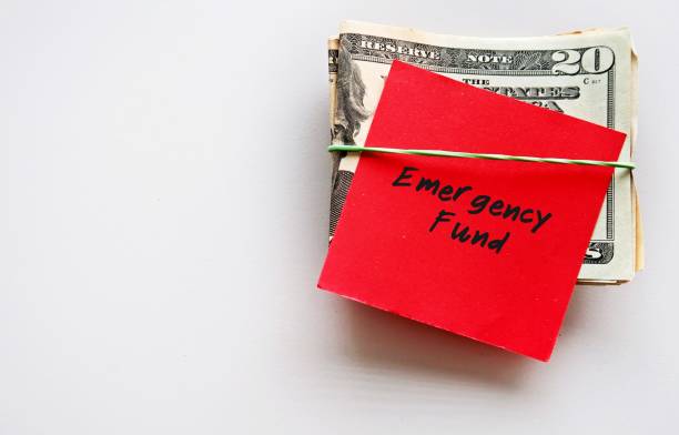 istock Dollars Money with red paper note and text written EMERGENCY FUND on copy space white background - cash reserve that's specifically set aside for unplanned expenses or financial crisis 1501537067