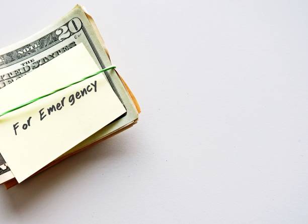 istock Dollars Money with paper note and text written FOR EMERGENCY  on copy space white background - cash reserve that's specifically set aside for unplanned expenses or financial crisis 1501538736