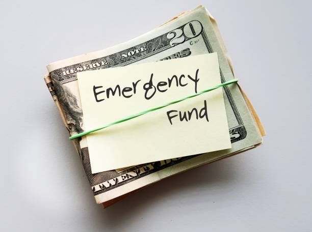 istock Dollars Money with paper note and text written EMERGENCY  FUND on copy space white background - cash reserve that's specifically set aside for unplanned expenses or financial crisis 1501538739