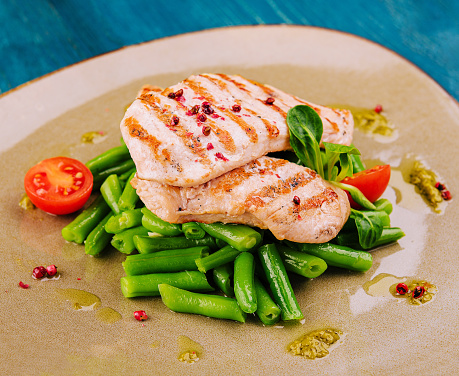 Grilled chicken fillets on green beans