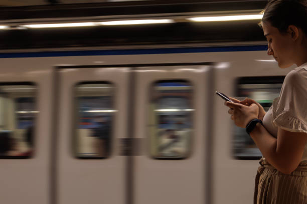 istock teenage girl using cell phone while passing subway or subway train with copy space 1501612031