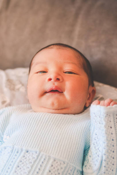 istock Newborn baby lying down and smiling on camera 1501633216