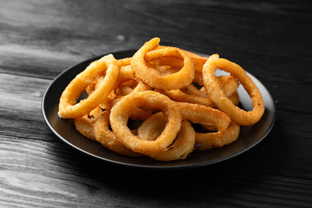 istock Crunchy Fried Battered onion rings on black plate 1501647323