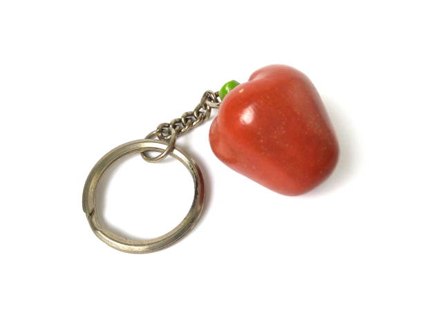 Close up of artificial red apple with key chain isolated on white background.