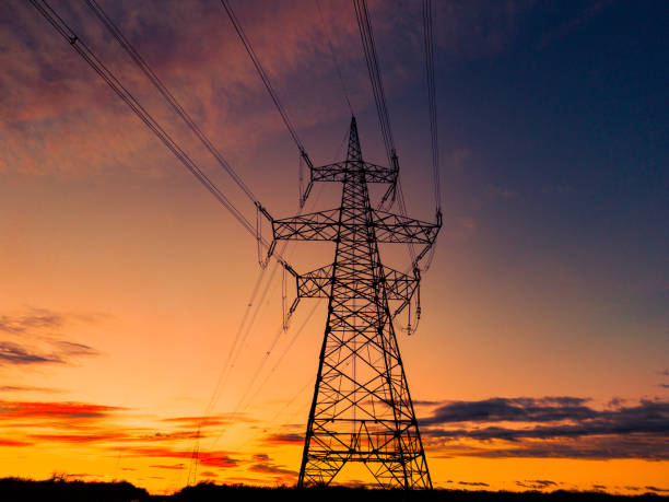 istock Silhouette of high voltage power lines and pylons under cloudy sky 1501651753