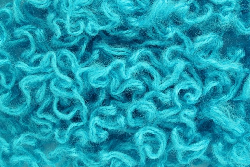 Close-up of colourful merino wool deep blue striped background. Abstract handmade craft knitting yarn textured pattern flatlay. Holiday christmas concept. Idea for felting, needlework, hobby. Mock up