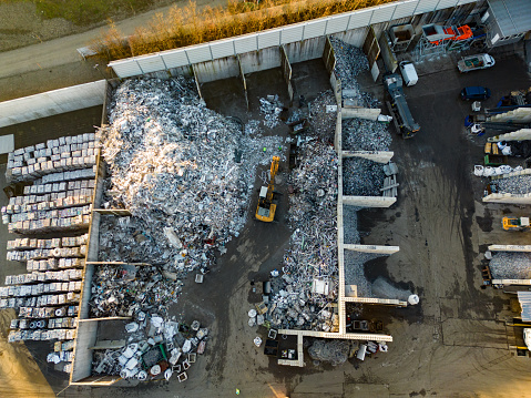 Aerial view of industrial scrap metal recycling in junkyard. Heap of waste in warehouse