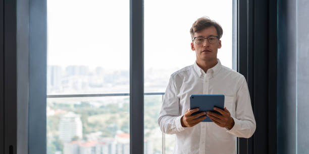 istock Businessman standing with tablet in hands near panoramic window 1501719830