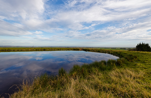 A beautiful dam under a cloudy sky on a farm near George, Western Cape, South Africa.