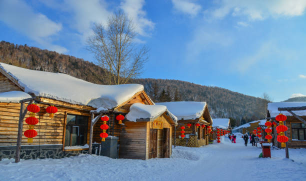 Harbin, China - Feb 24, 2018. Wooden houses with red lanterns in snow at mountain township in Harbin, China.