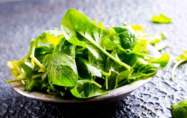 istock Fresh baby spinach leaves in bowl on stone background 1501731584