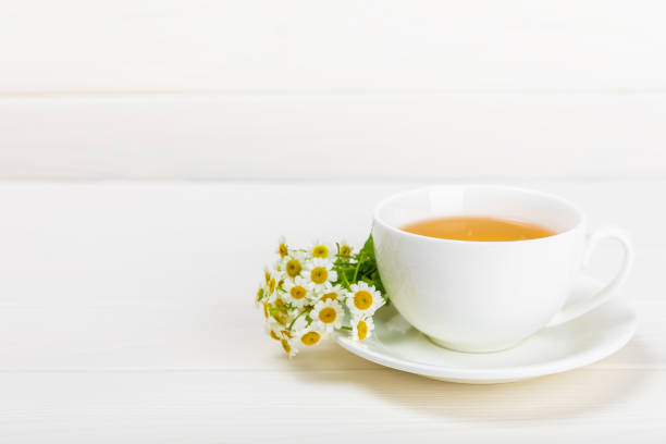 istock Chamomile tea in a cup on a white texture background. Natural hour with chamomile flowers. Herbal tea. Immunity tea.Natural healer concept. Healthy detox drink.Close up. Place for text. 1501738325