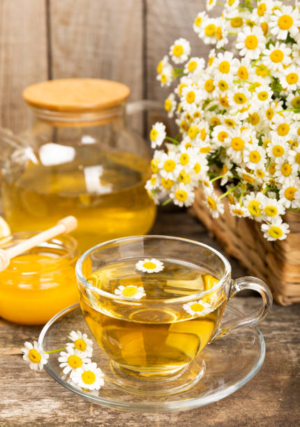 istock Chamomile tea in a  cup on a brown textured background. Natural hour with chamomile flowers. Herbal tea. Natural healer concept. Healthy detox drink.Close up. Place for text. Copy space. 1501738346