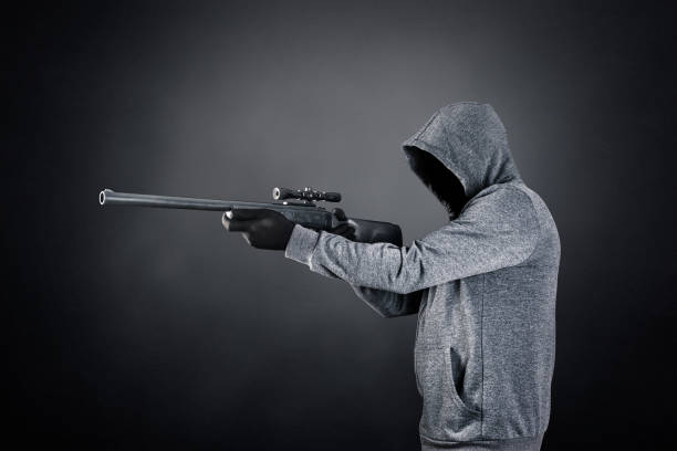 istock Hooded man with rifle over dark misty background 1501748029