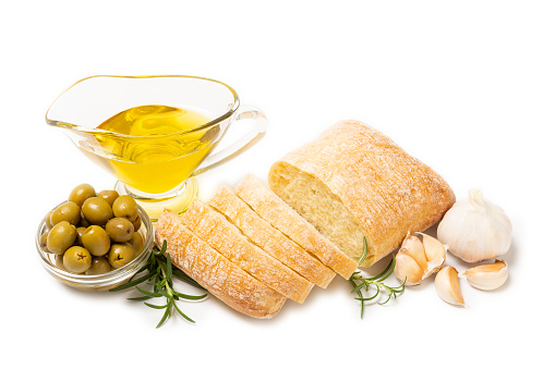 Italian ciabatta bread cut in slices with herbs, olives, garlic and parmesan cheese isolated on white background. Italian food. Delicacy. Vegan food.