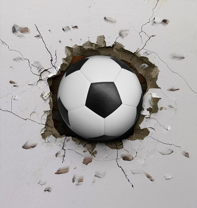 The soccer ball flew through the wall with a crack.