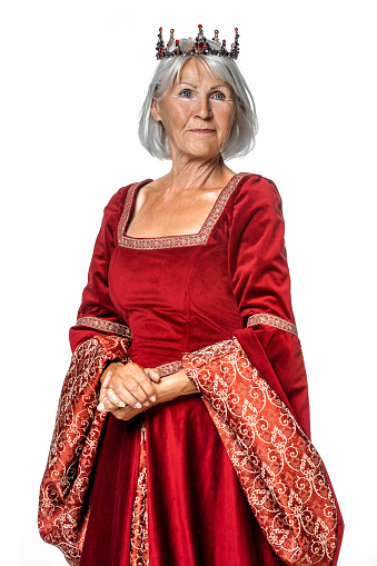 Portrait of a beautiful senior caucasian female queen figure wearing a luxury dress in a studio shoot