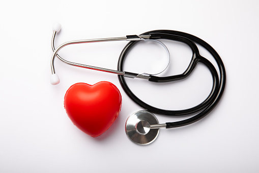 Black stethoscope and red heart isolated on white background, close up. Healthcare. Place for text. Medicine concept. The concept of cardiology.