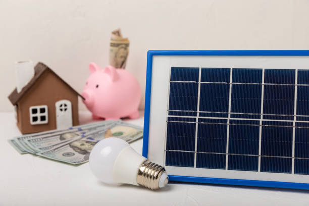 istock Flat lay composition with solar panel, led lamp. house model and piggy bank on cement background. The concept of saving money and clean energy. The concept of ecology and sustainable development. 1501752961