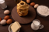 Baumkuchen, sakotis ,sekacz at center and ingredients around on wooden table, traditional sweet spit cake made of butter, eggs, flour, sugar. Horizontal plane