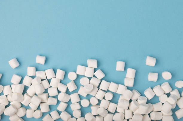 istock Loose marshmallows on a blue background. White marshmallow flat lay. Sweets and snacks for a snack. Chewing candies close-up. Copy space. Place for text. Winter food concept. 1501753942