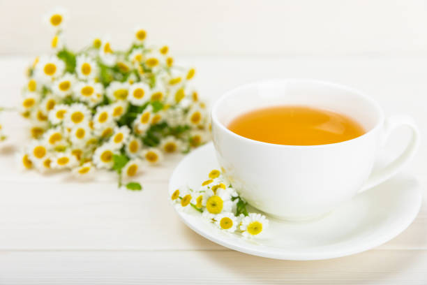 istock Chamomile tea in a cup on a white texture background. Natural hour with chamomile flowers. Herbal tea. Immunity tea.Natural healer concept. Healthy detox drink.Close up. Place for text. 1501755252