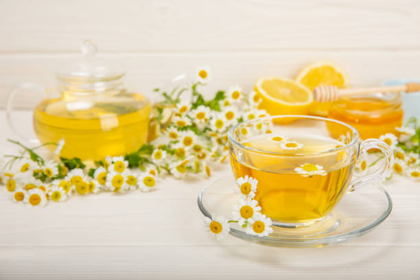 istock Chamomile tea in a cup on a white texture background. Natural hour with chamomile flowers. Herbal tea. Immunity tea.Natural healer concept. Healthy detox drink.Close up. Place for text. 1501755288