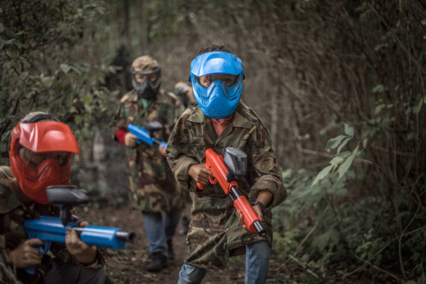Young children playing paintball together during a skirmish