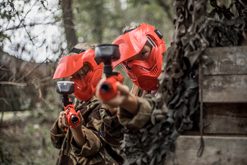 Young children playing paintball together during a skirmish