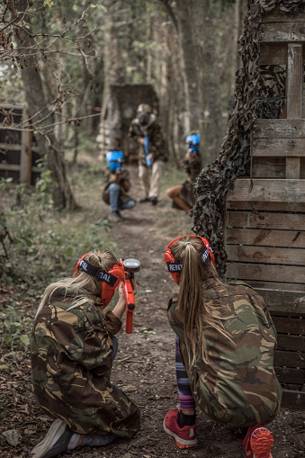 Young children playing paintball together during a skirmish