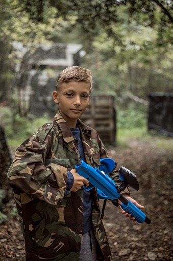 A young male paintball team player during the game
