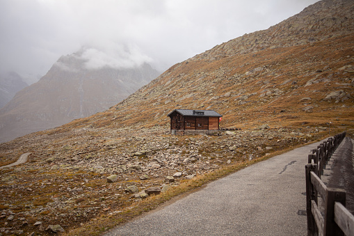 Wooden house in the mountains on a background of snow-capped mountains