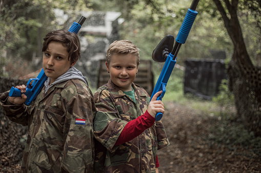 Portrait of two young children paintball team players