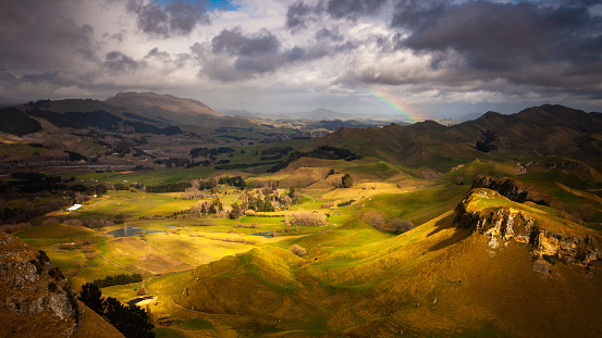 A rainbow appears as storm clouds move across the hills of Havelock North, a quaint village just outside Hastings. In the distance lies the Rauhine Mountain ranges.